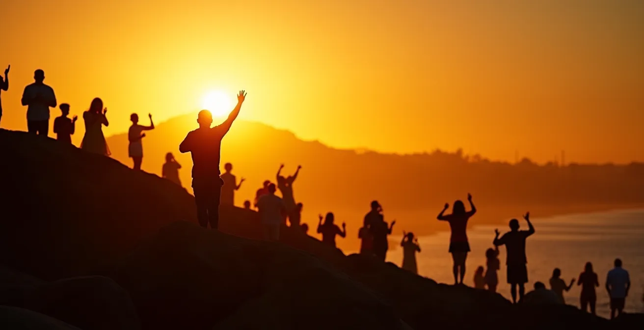 Goldener Sonnenuntergang über dem Arpoador-Felsen mit Silhouetten applaudierender Menschen